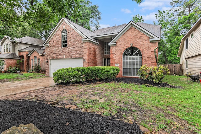 traditional-style house with brick siding, fence, a shingled roof, and a garage