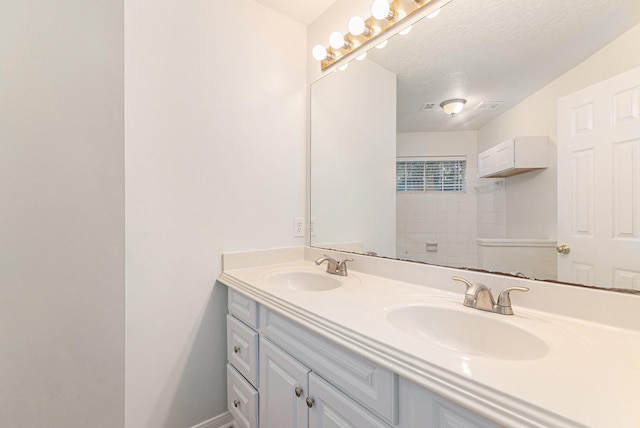 bathroom with baseboards, a sink, and double vanity