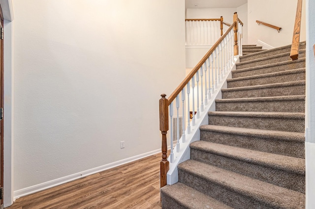 stairs with baseboards and wood finished floors