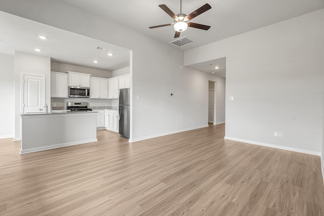 unfurnished living room with light wood-style floors, ceiling fan, visible vents, recessed lighting, and baseboards