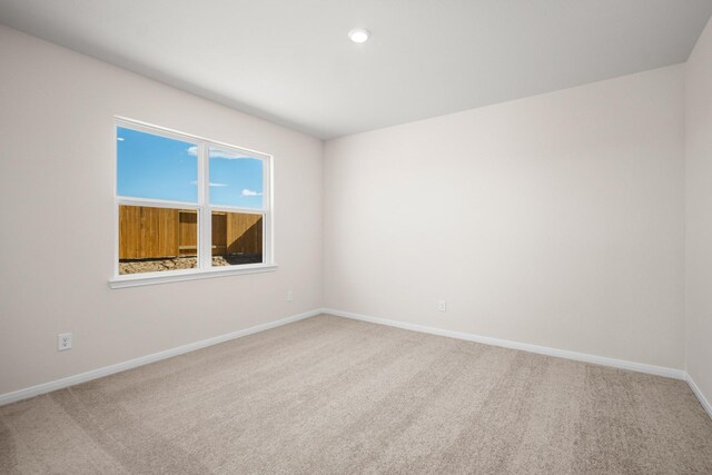 carpeted empty room with baseboards and recessed lighting
