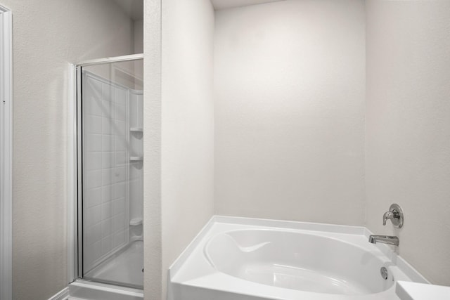 bathroom featuring a stall shower and a garden tub