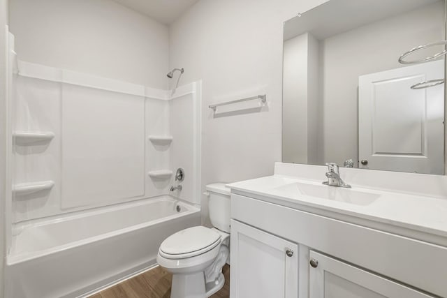bathroom featuring toilet, wood finished floors, vanity, and shower / bathtub combination