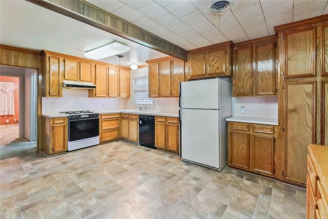 1220 San Felipe St, Angleton, TX 77515 - kitchen with range with gas stovetop, freestanding refrigerator, black dishwasher, under cabinet range hood, and visible vents