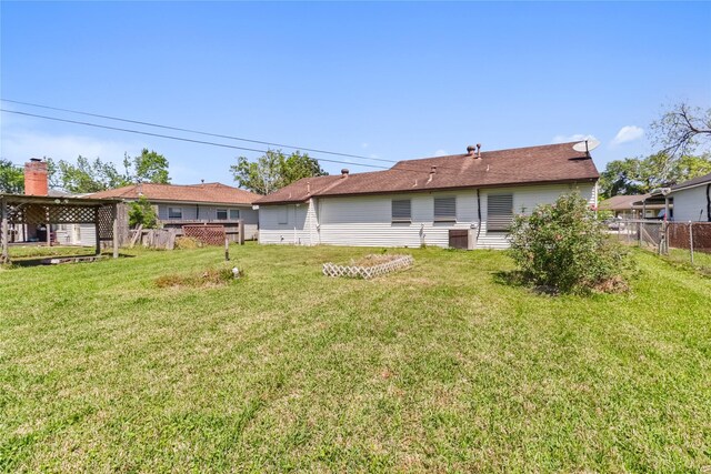 1220 San Felipe St, Angleton, TX 77515 - back of house featuring a yard and fence