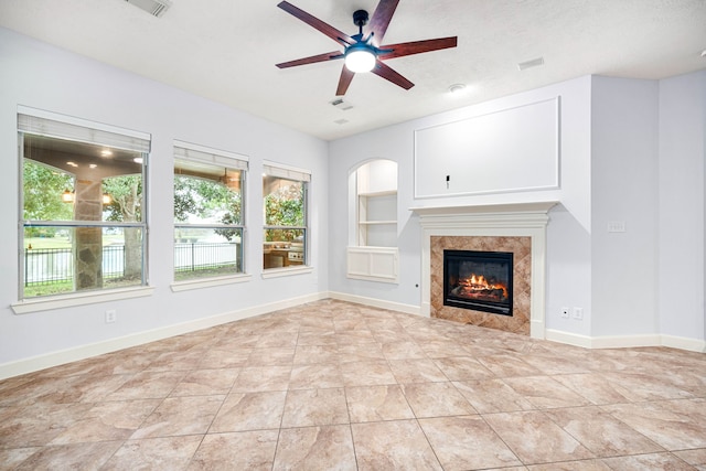 2117 Quiet Falls Ln, League City, TX 77573 - unfurnished living room featuring a healthy amount of sunlight, a ceiling fan, built in shelves, and a fireplace