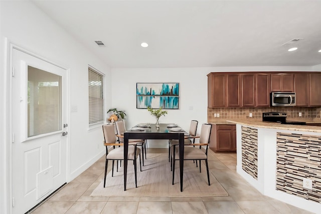 6 Whitekirk Pl, Magnolia, TX 77354 - kitchen featuring stainless steel appliances, tasteful backsplash, light tile patterned floors, and visible vents