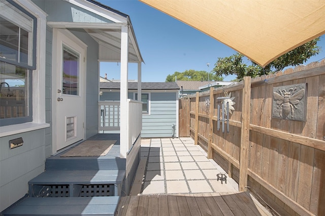 exterior space featuring a deck, roof with shingles, and fence