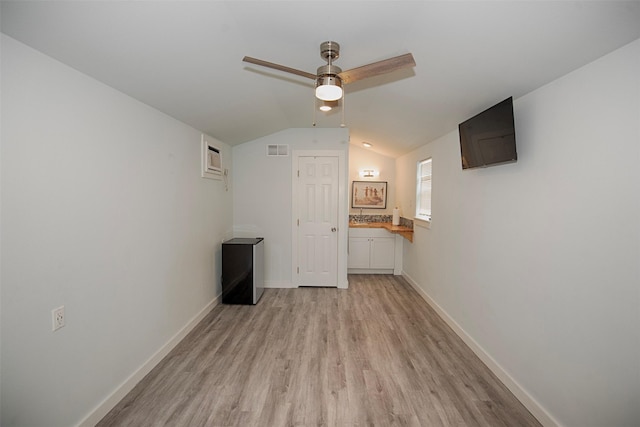 unfurnished room featuring a ceiling fan, lofted ceiling, baseboards, light wood finished floors, and visible vents