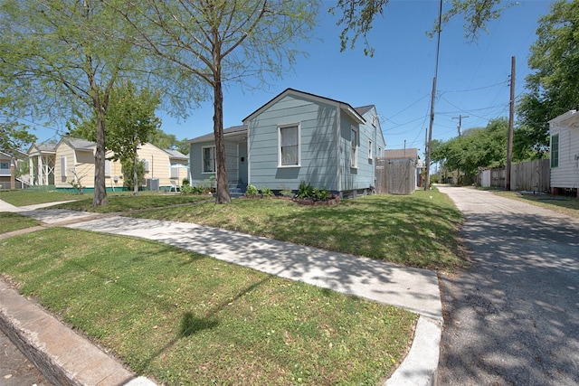 view of front of house featuring a front lawn and fence