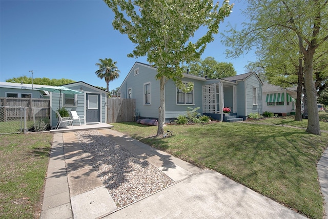 view of front of property with fence, an outbuilding, and a front yard