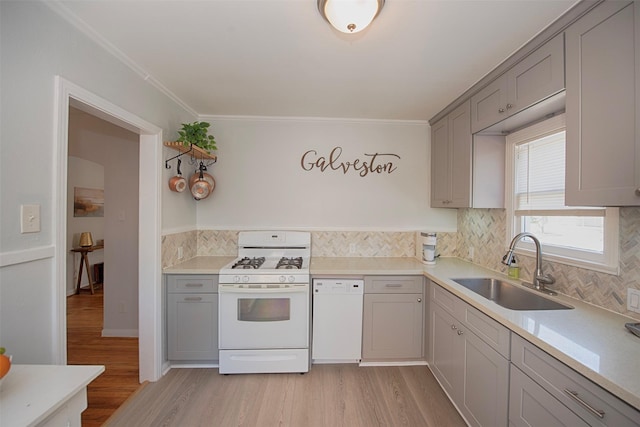 kitchen featuring a sink, light wood-style flooring, white appliances, and gray cabinets