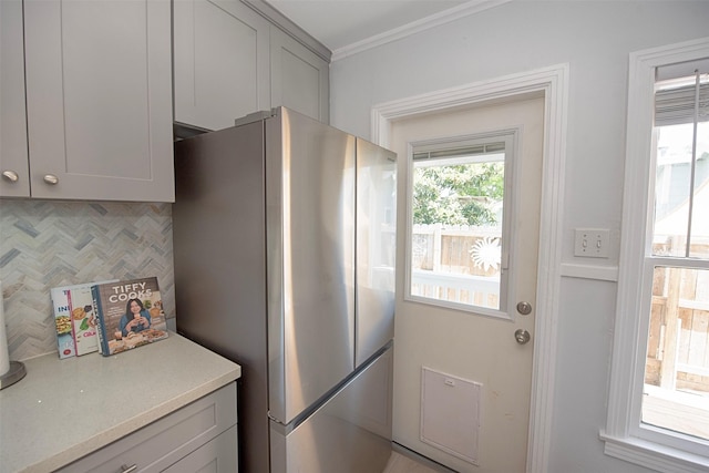 kitchen featuring freestanding refrigerator, light countertops, gray cabinets, and ornamental molding