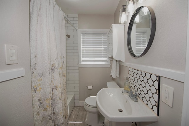 bathroom with a sink, toilet, and shower / tub combo