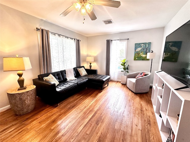living room with ceiling fan, light wood-type flooring, and visible vents