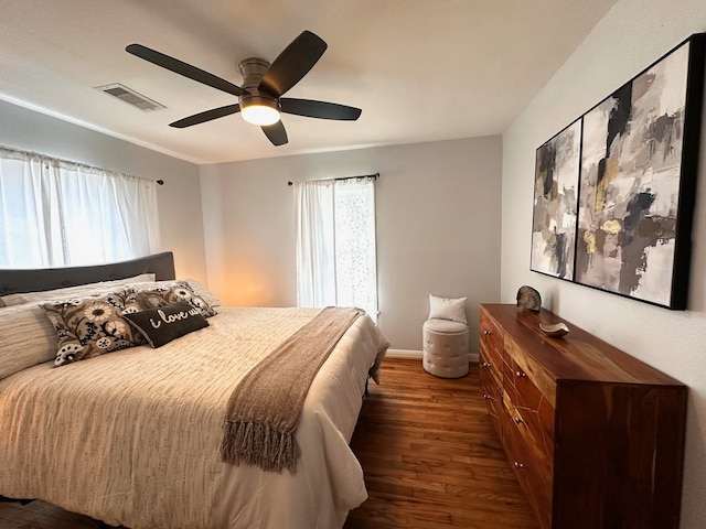 bedroom with baseboards, ceiling fan, dark wood finished floors, and visible vents