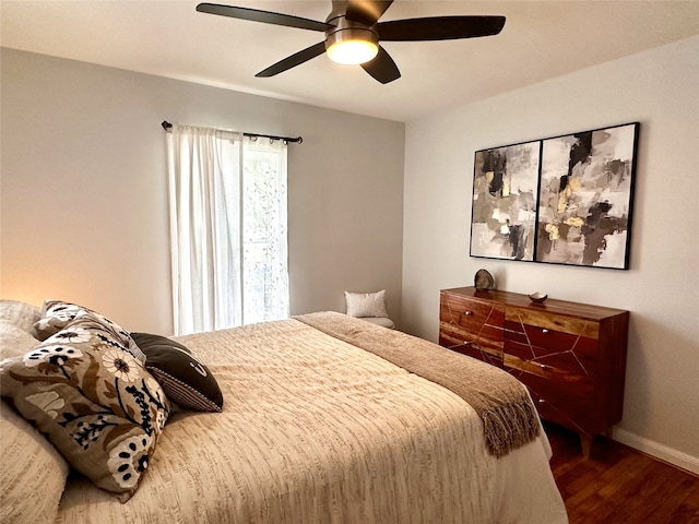 bedroom with a ceiling fan, wood finished floors, and baseboards