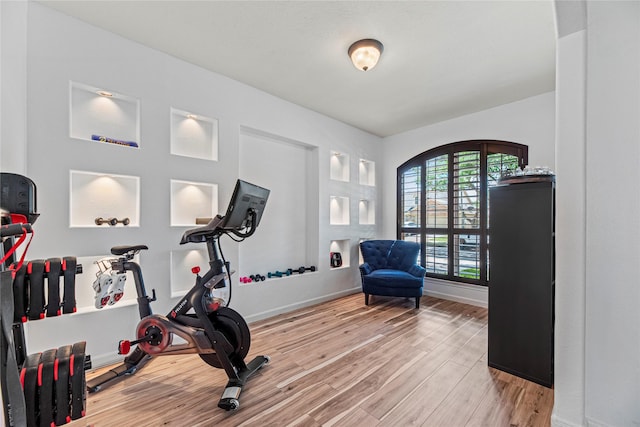 workout area featuring baseboards and wood finished floors