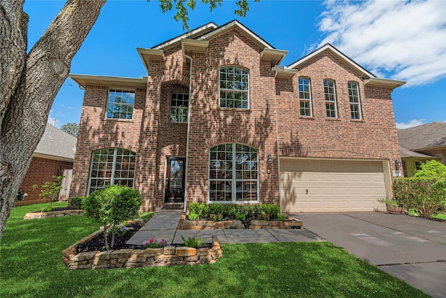 view of front of house featuring brick siding, driveway, an attached garage, and a front yard