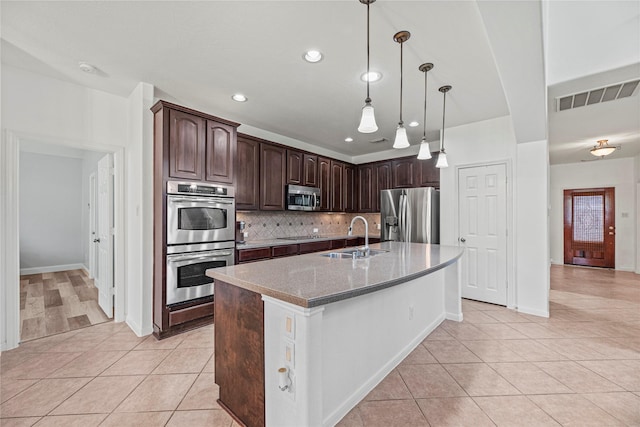 kitchen with light tile patterned flooring, visible vents, stainless steel appliances, and a sink