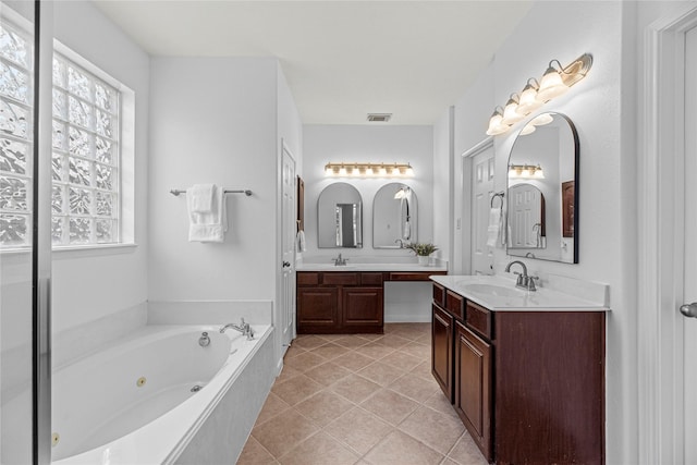 bathroom featuring plenty of natural light, tile patterned flooring, a sink, and visible vents