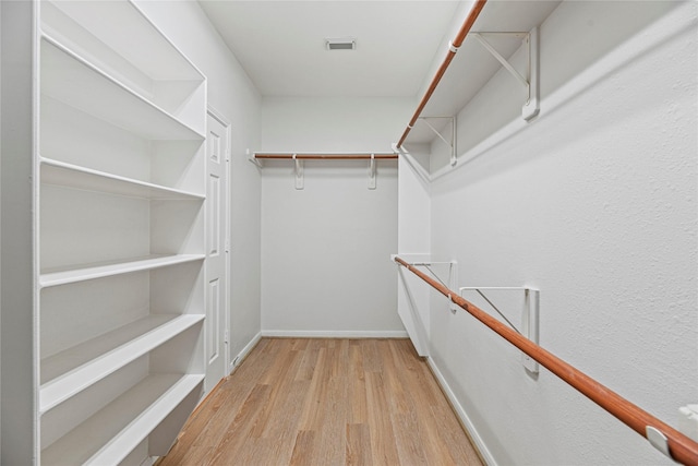 walk in closet with visible vents and wood finished floors