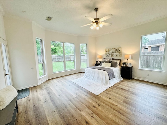 bedroom with visible vents, ornamental molding, and wood finished floors