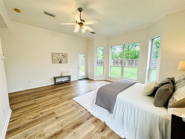 bedroom featuring visible vents, access to outside, wood finished floors, and multiple windows