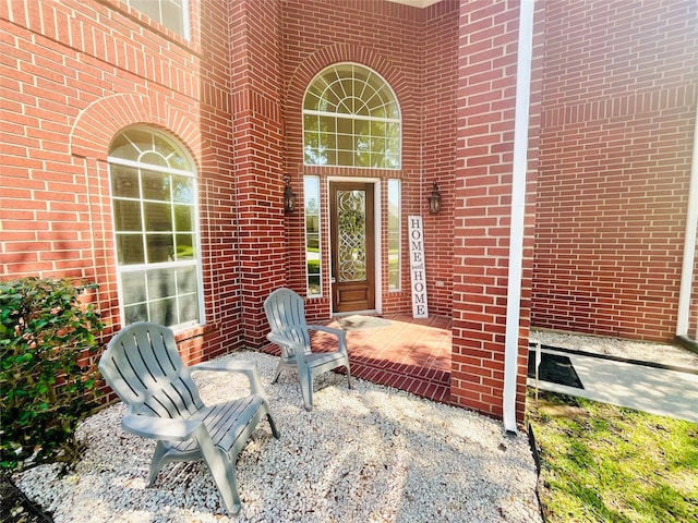 view of exterior entry featuring brick siding