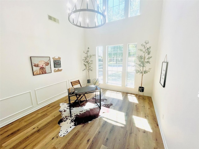 office space featuring wood finished floors, visible vents, and plenty of natural light