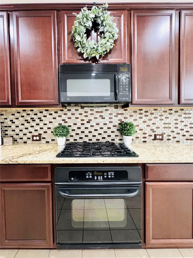 kitchen with light stone countertops, tile patterned floors, backsplash, and black appliances