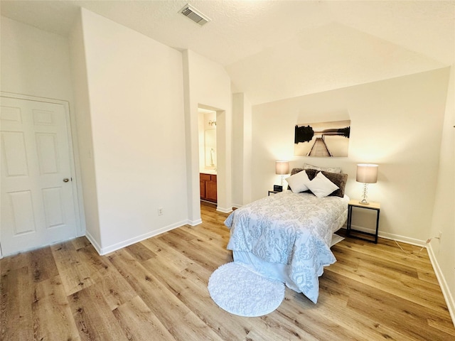 bedroom with lofted ceiling, visible vents, baseboards, and light wood-style flooring