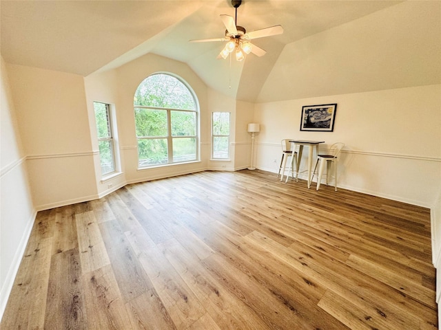 interior space with baseboards, a ceiling fan, wood finished floors, and lofted ceiling