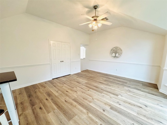 unfurnished bedroom featuring a closet, light wood-style floors, ceiling fan, and lofted ceiling
