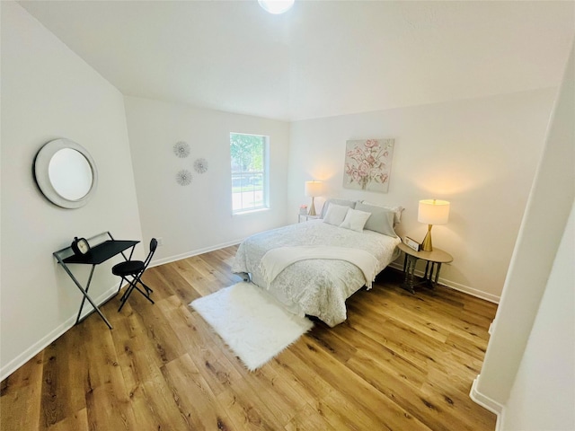 bedroom with baseboards and wood finished floors