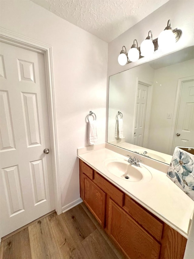 bathroom featuring vanity, a textured ceiling, and wood finished floors