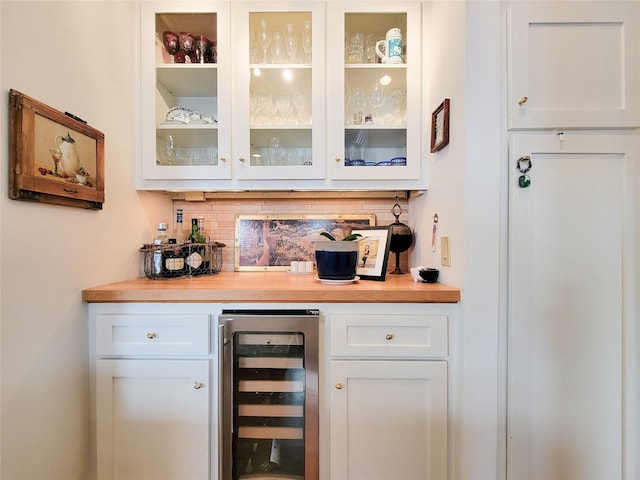 bar featuring a bar, beverage cooler, and decorative backsplash
