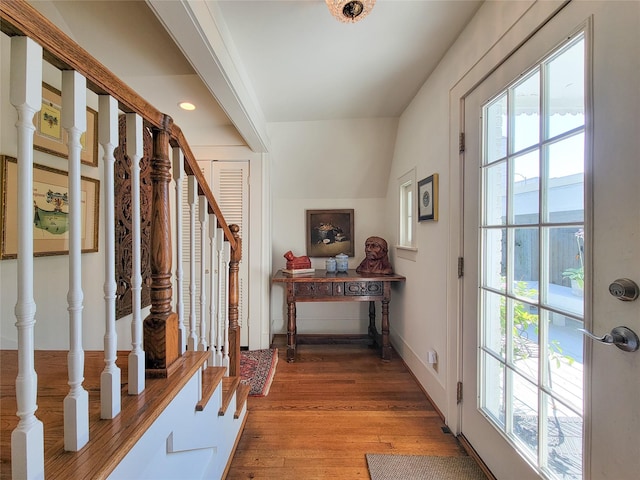 doorway to outside featuring light wood-style flooring, baseboards, and stairway