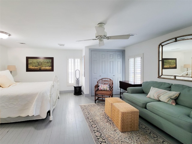 bedroom with a closet, visible vents, multiple windows, and ceiling fan