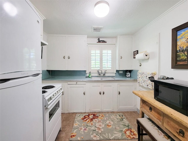 kitchen with visible vents, white cabinets, a sink, light countertops, and white appliances