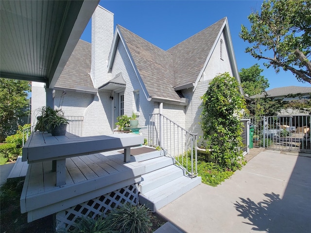 view of front facade with fence, brick siding, and a chimney