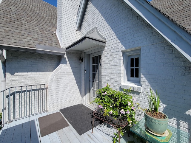property entrance featuring roof with shingles