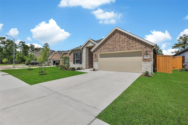 15415 Surrey Pines Ln, Houston, TX 77044 - view of front of home featuring an attached garage, driveway, stone siding, and brick siding