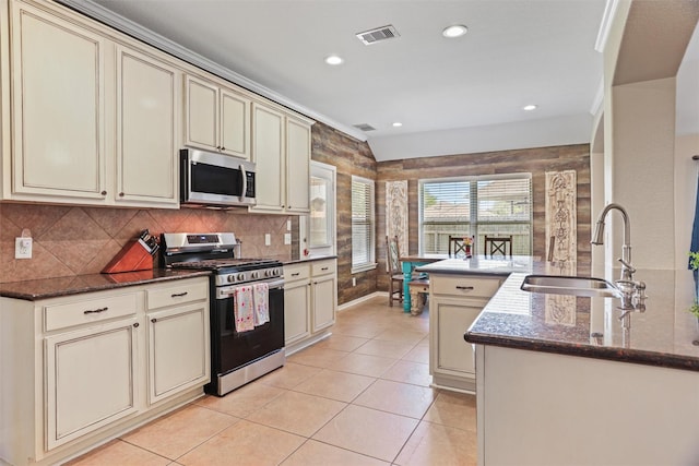 kitchen featuring appliances with stainless steel finishes, a sink, visible vents, and cream cabinetry