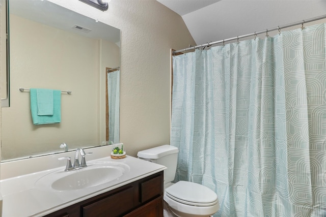 full bath featuring vanity, a textured wall, toilet, visible vents, and lofted ceiling