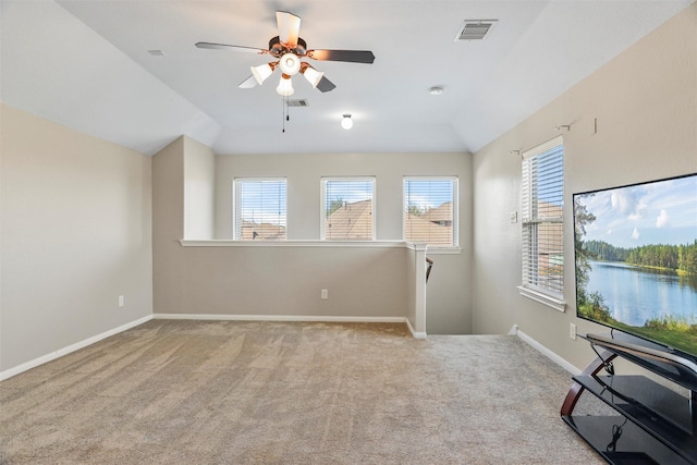 empty room featuring carpet floors, vaulted ceiling, and a healthy amount of sunlight