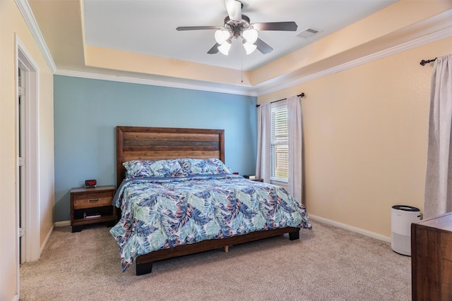 carpeted bedroom featuring ornamental molding, visible vents, a raised ceiling, and a ceiling fan