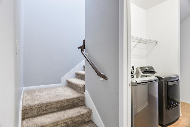 clothes washing area featuring washer and dryer, laundry area, and baseboards