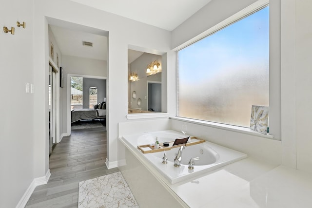 full bathroom featuring baseboards, connected bathroom, a garden tub, and wood finished floors