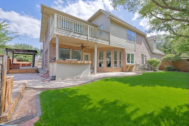 rear view of house featuring a balcony, ceiling fan, brick siding, and a patio